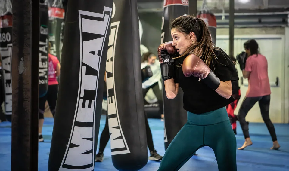 Boxing fitness près de Blagnac : une pratiquante travaille sa frappe au sac dans une salle Boxing Center.