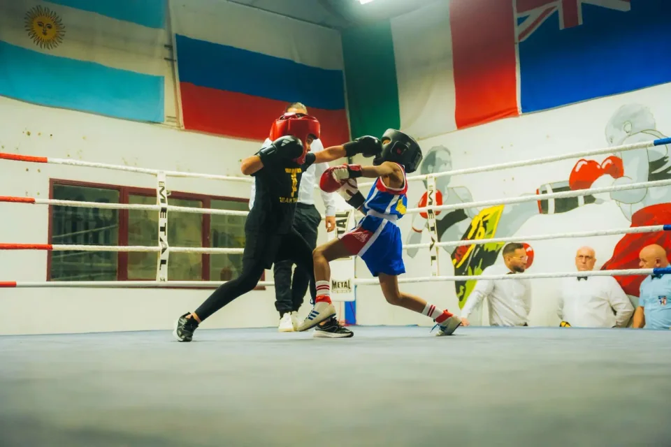 Boxe enfants proche de Blagnac : deux jeunes boxeurs casqués lors d’un tournoi de boxe éducative Boxing Center.