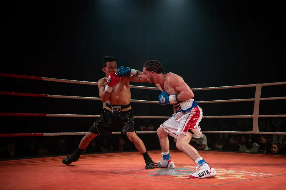 Deux boxeurs en compétition sur un ring, sous les projecteurs de la soirée Fight Event 4 de Boxing Center.